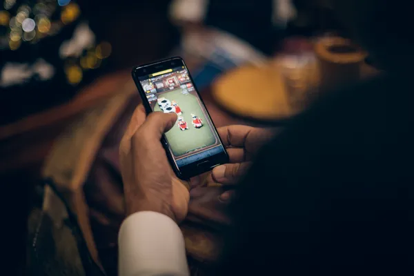 A man celebrating a winning moment on his laptop while gaming symbols float around him, capturing the excitement of 786TT games.